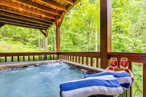 Soak under the trees in your private hot tub retreat—complete with twinkling string lights, bubbling warmth, and a forest backdrop made for unwinding.