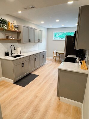Brand new kitchen with LVP flooring, white quartz countertops, and cabinets. 