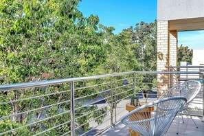 Step out from the primary bedroom to enjoy a quiet moment on the private balcony, overlooking leafy surrounds.