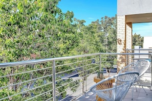 Step out from the primary bedroom to enjoy a quiet moment on the private balcony, overlooking leafy surrounds.