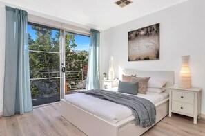 The primary bedroom offers a calming retreat with a queen bed, a walk-in wardrobe and direct access to an ensuite.