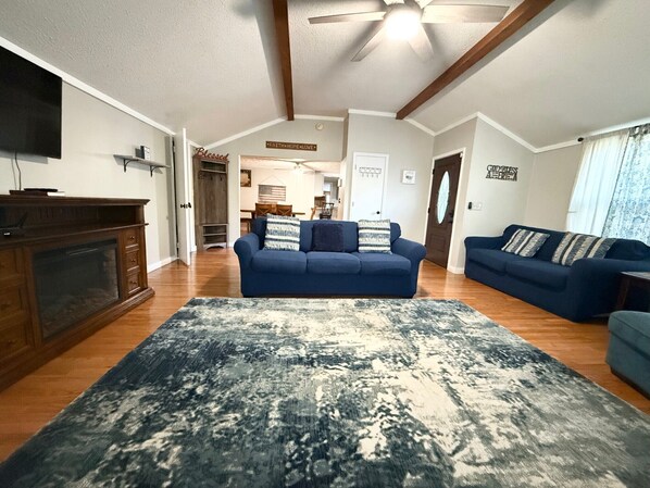 Living room has a couch, love seat, large chair, rocking chair, and bench.
