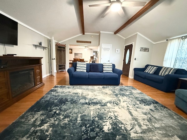 Living room has a couch, love seat, large chair, rocking chair, and bench.
