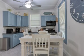 The fully furnished kitchen is equipped with dishes, utensils, and appliances.