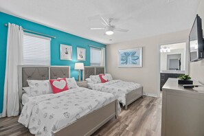 Bedroom with 2 double beds and a TV—ideal for relaxing after a fun-filled day.