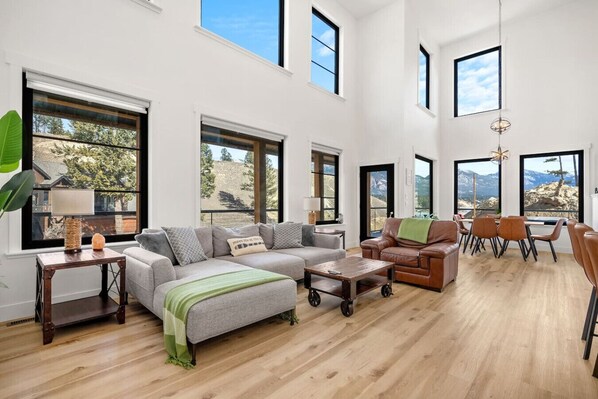 Living room with a 65" Smart TV, sound system, electric fireplace, board games and cozy seating options.