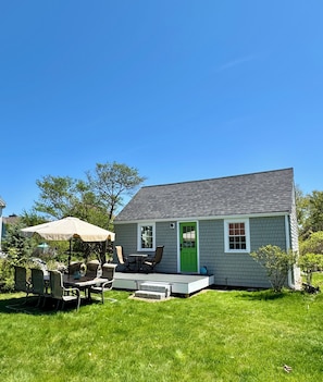 Front of cottage, front deck, large dining table off deck.