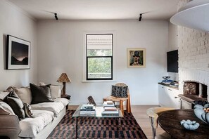 A feather filled sofa invites you in to brows the art books by the fireplace or watch a movie after a day of exploring.