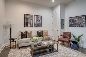 Unit 1: Open concept living room complete with designer furnishings and smart TV.