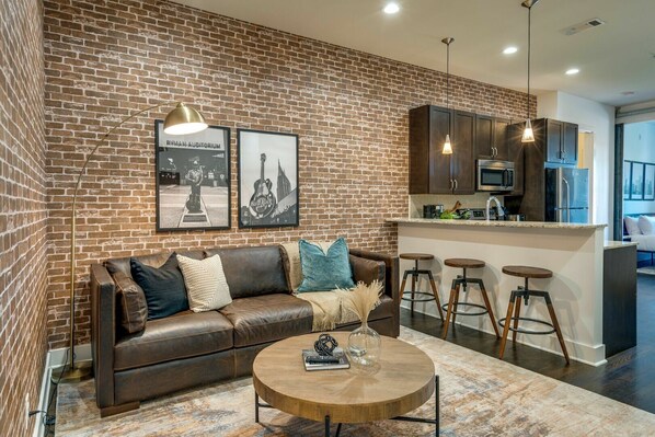 Unit 2: Open concept living area with designer furnishings and smart TV.