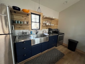 Kitchen includes 4 burner stove, oven, full size fridge and freezer
