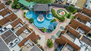 Behold the stunning vista of Porta Al Sole's pool area, bathed in the golden glow of daylight. From high above, the azure waters shimmer, inviting you to immerse yourself in their refreshing embrace