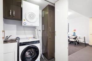 Discover the convenience of a well-organized laundry area, neatly integrated with storage and a practical sink.