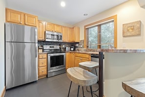 Kitchen - Fully remodeled kitchen is gorgeous with new countertops, backsplash, and stainless steel appliances. Cupboards contain all needed to cook and dine.