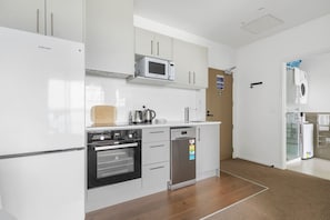 The kitchen has a fridge freezer, built-in oven, cooktop, dishwasher drawer, microwave, and range hood.