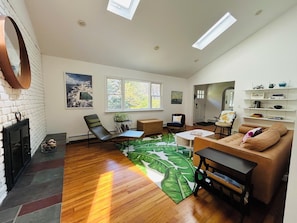 Large windows, skylights showcasing secluded property and mature landscaping.