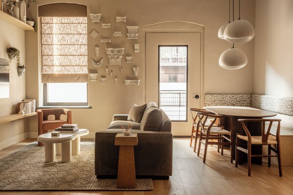 A shot of the living room showcasing the sofa, dining banquette and decor.