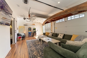 Our beautiful game room - 70" TV & arcade games - garage doors open for sunshine