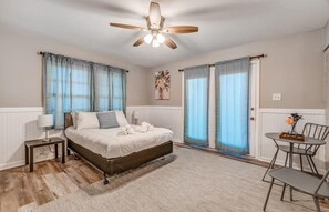 Bedroom with full bed, sitting area, and access to back patio