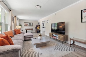 The family room is the heart of the home—a space where comfort meets connection, and every detail invites you to unwind. Soft, oversized sofas draped with cozy throws beckon you to sink in, while a plush rug cushions your steps, adding warmth and texture