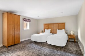 Simplistic twin beds with essential comforts and soft lighting.