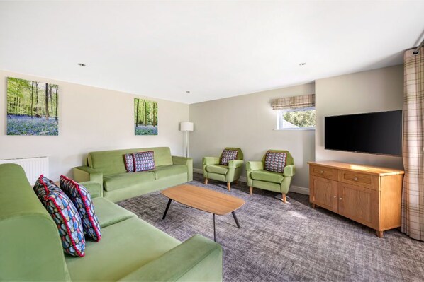 Open-plan living room with garden views and cozy fireplace.