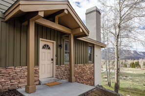 Inviting entryway with rustic wood and stone finishes, opening to peaceful mountain views and tall aspens all around.