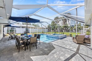 Welcome to the fun zone!  The screened pool and patio area with dining and lounge areas.  Chaises are far left  for soaking up the sun.