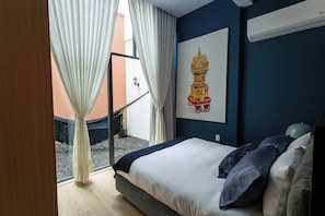 Habitación con cama queen, cuenta con vista a un pequeña terraza interior con hamaca. Disfruta del aire acondicionado y espacios cómodas para tu estancia