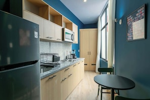 Cocina completa para tu estancia, cuenta con refrigerador, microondas, parilla eléctrica y cafetera. Así como un comedor para dos personas 