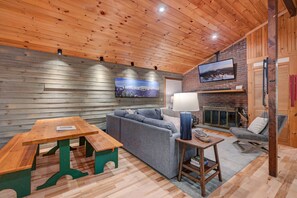 Spacious den with a large TV, comfy seating, board games, and ring toss—perfect for family fun.