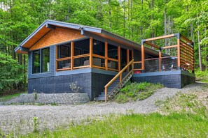 Modern chalet with private hot tub, forest views, and cozy indoor-outdoor living.