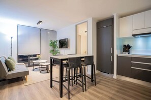Experience modern comfort in this stylish open-plan living area, complete with a sleek kitchen and cozy seating.