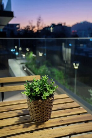 Relax on the charming patio with a stunning cityscape view at dusk, perfect for unwinding after a day of exploration.