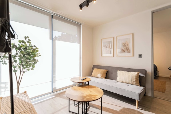 Bright and cozy living room with modern decor and natural light, perfect for relaxation.