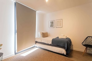 Cozy bedroom with natural light and modern decor, perfect for a restful stay.