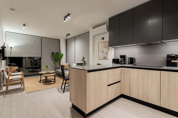 Experience modern comfort in this stylish open-plan living area with a sleek kitchen and cozy seating, perfect for relaxation and entertaining.