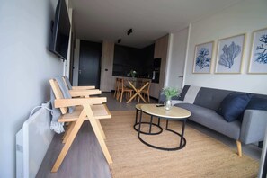 Experience modern comfort in this stylish living area, featuring chic decor and an open kitchen for a perfect getaway.