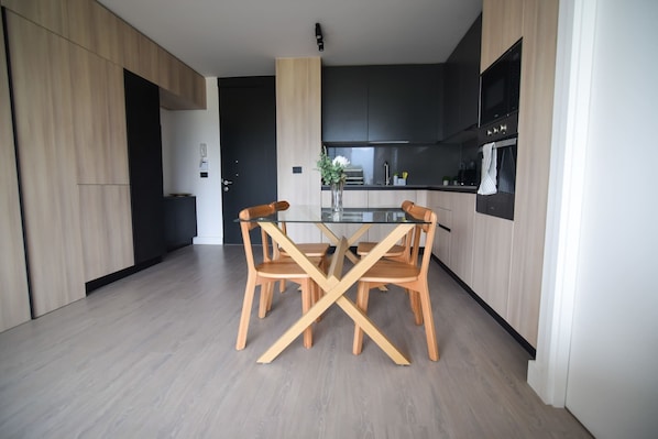 Experience modern living in this stylish kitchen and dining area, perfect for enjoying meals together in a chic, minimalist setting.
