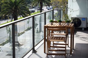 Enjoy a serene moment on the balcony with a view of palm trees and the city. Perfect for morning coffee or evening relaxation!