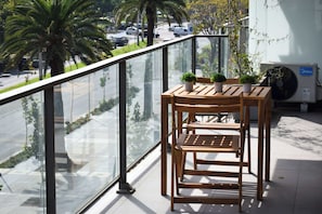 Enjoy a serene moment on the balcony with a view of palm trees and the city. Perfect for morning coffee or evening relaxation!