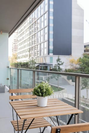 Enjoy a cozy moment on your private balcony, surrounded by modern architecture and a touch of greenery.