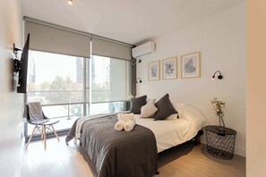 Experience comfort in this modern bedroom with natural light, stylish decor, and a cozy balcony view. Perfect for a relaxing getaway!