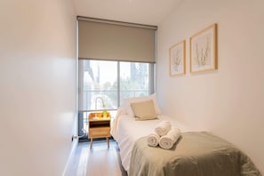 Cozy and bright bedroom with a single bed, perfect for a restful stay. Enjoy natural light and modern decor for a relaxing atmosphere.
