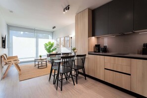 Experience modern comfort in this stylish living space, featuring a sleek kitchen, cozy dining area, and abundant natural light.
