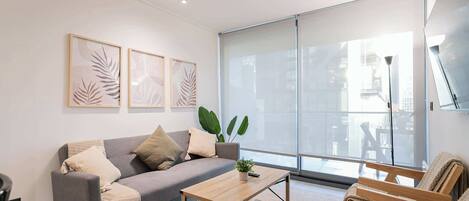 Bright and modern living room with cozy seating and natural light, perfect for relaxation and unwinding.