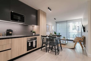 Sleek modern kitchen and dining area with abundant natural light, perfect for cozy meals and relaxation.