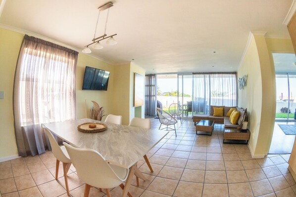 Open plan living/dining room from kitchen. Sliding doors on to private patio.