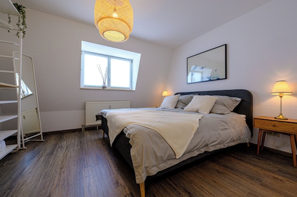 Großzügiges Schlafzimmer mit Kingsize Bett (180x200cm) für erholsamen Schlaf.