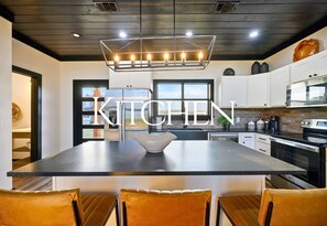 The oversized kitchen island is the hub of the cabin — the perfect spot to whip up a meal, pour a round of coffee, or spread out a puzzle for a laid-back afternoon.